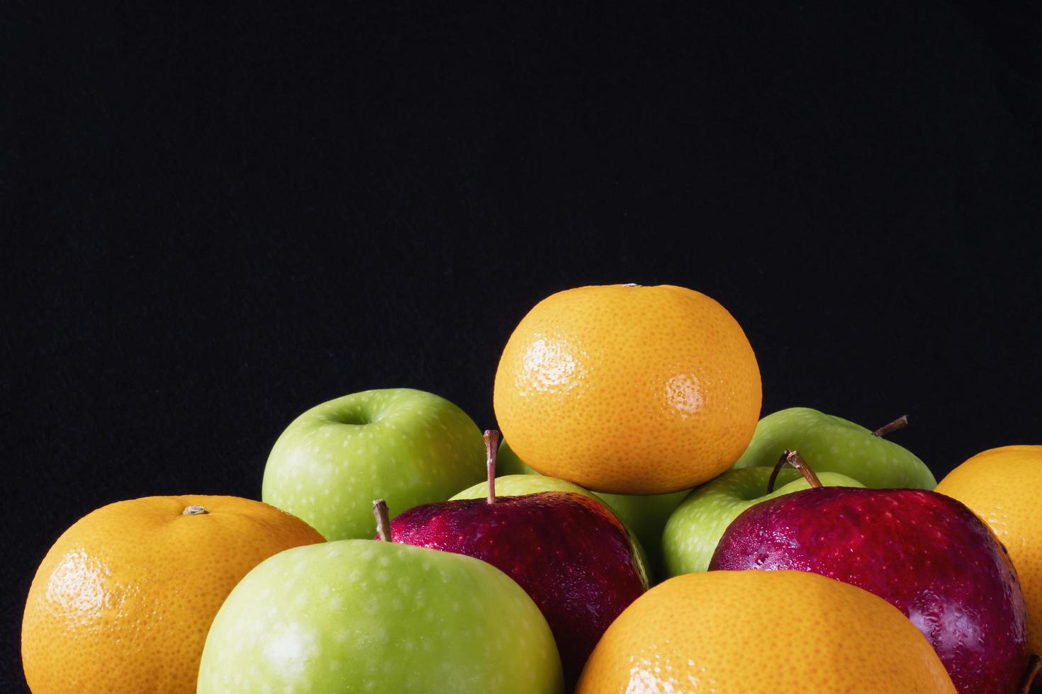 Fresh red green apple and orange over gray black background - fresh fruit background concept photo