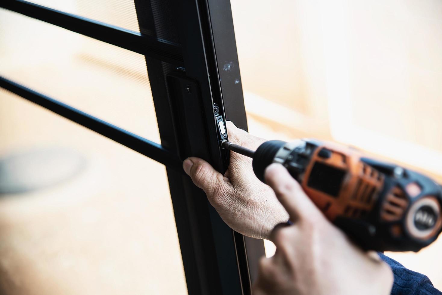 Man doing aluminum frame with glasses and wire screen door and window installation work in construction site photo