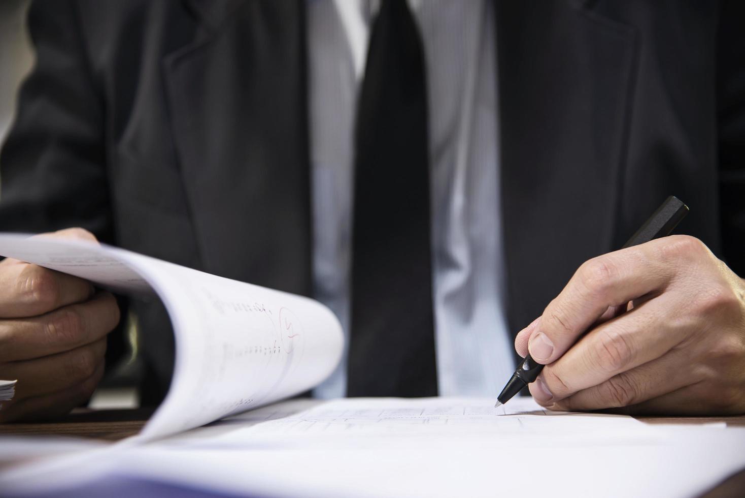 Businessman holding pen while working with document - business people working concept photo