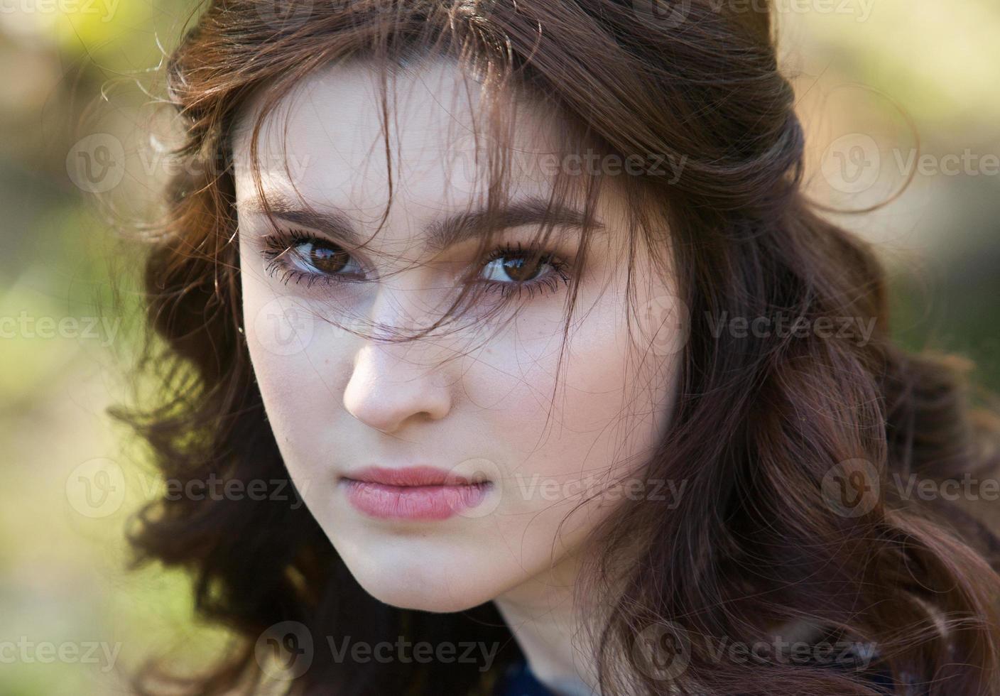 beautiful white european girl with clean skin in the park with flowering trees photo