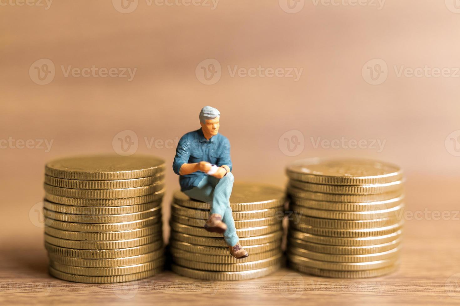 Miniature people A businessman is seated atop a mound of money photo