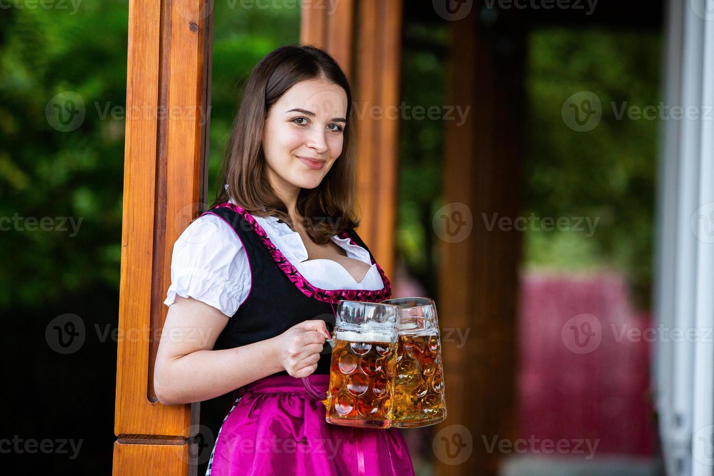 Sexy russian woman in Bavarian dress holding beer mugs. photo