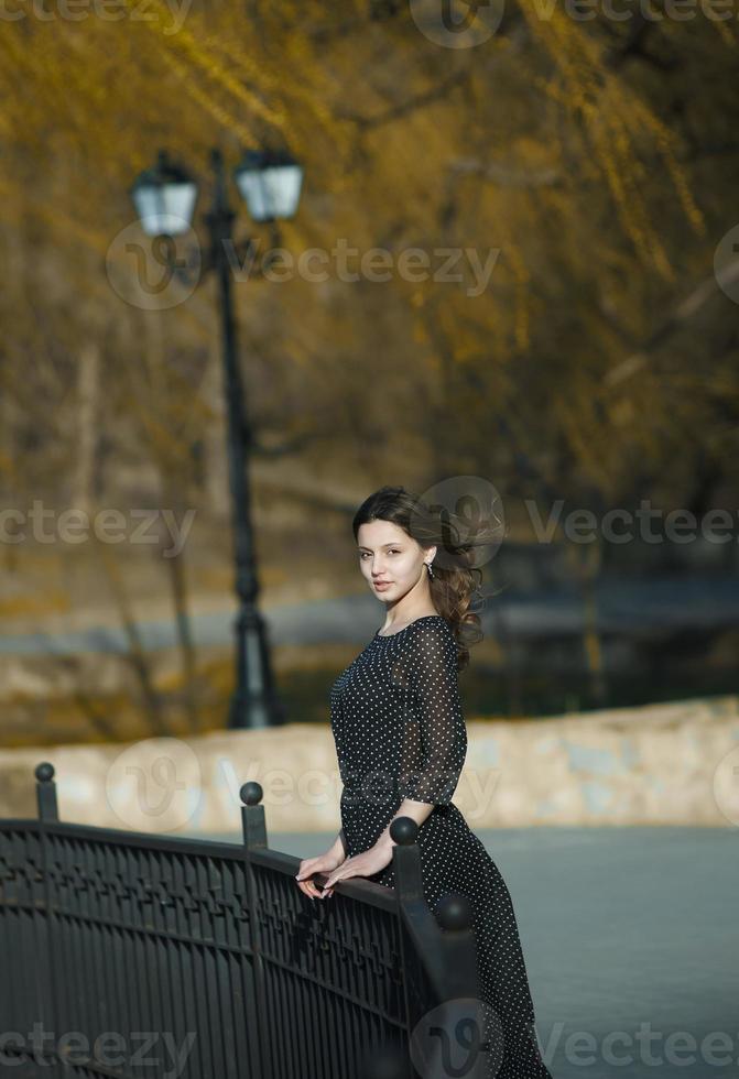 retrato de mujer con un cabello moviéndose en el viento. primer plano retrato de joven hermosa chica morena rusa en el parque verde de verano. mujer blanca europea vestida. foto