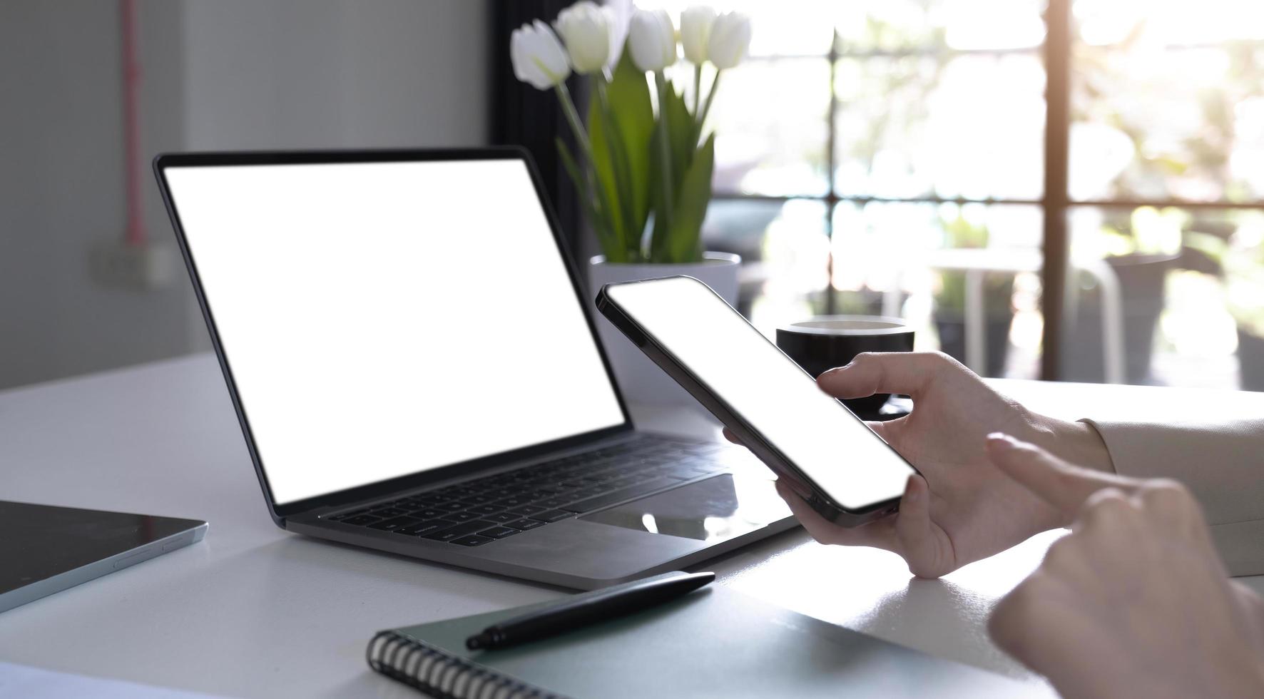 computer,cell phone mockup image blank screen with white background for advertising text,hand woman using laptop texting mobile contact business search information on desk in cafe.marketing,design photo