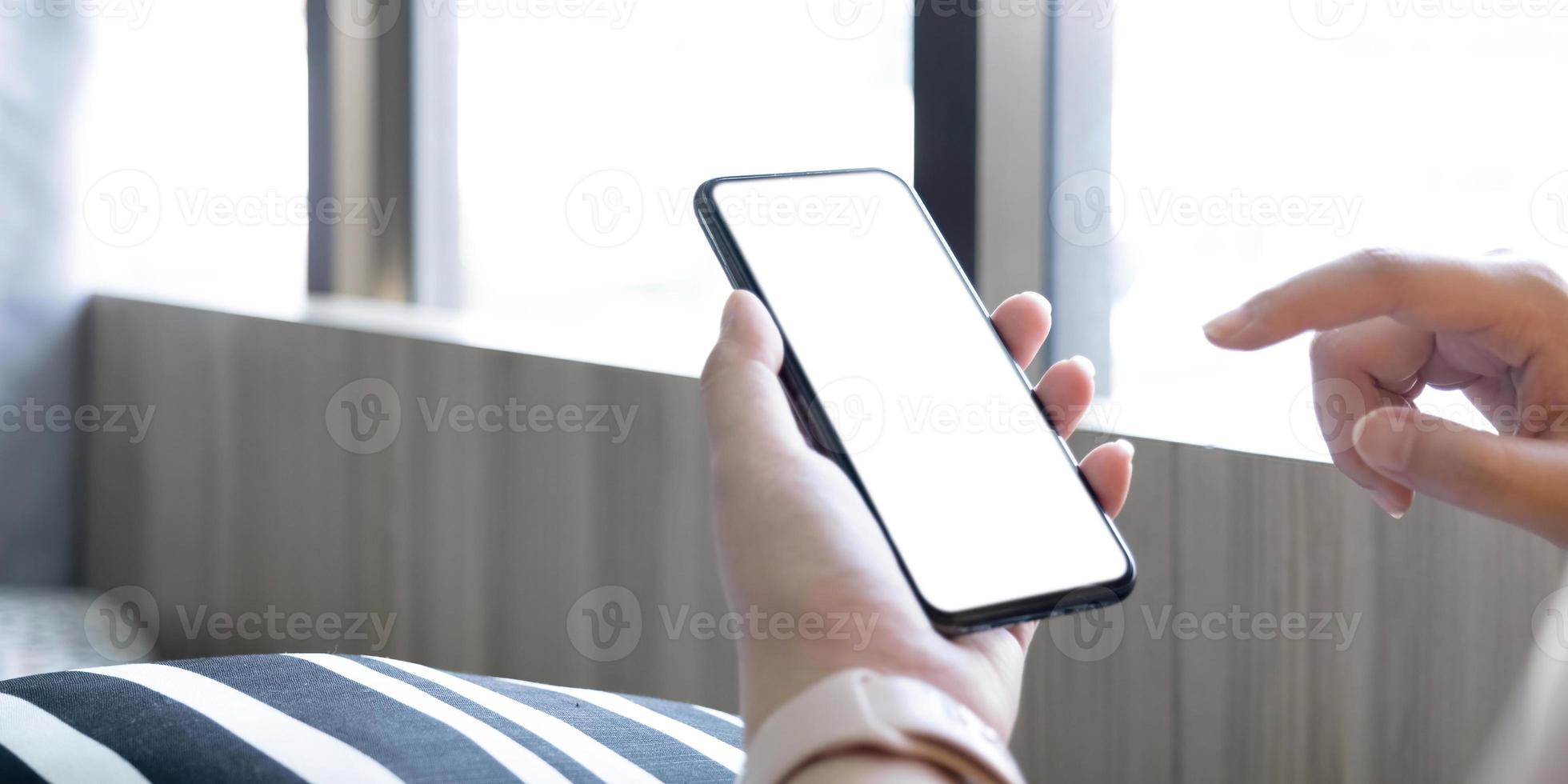 vista recortada de manos de hombre sosteniendo un teléfono inteligente con pantalla de espacio de copia en blanco para su mensaje de texto o contenido de información, mensaje de texto de lectura femenina en el teléfono celular durante el entorno urbano. foto