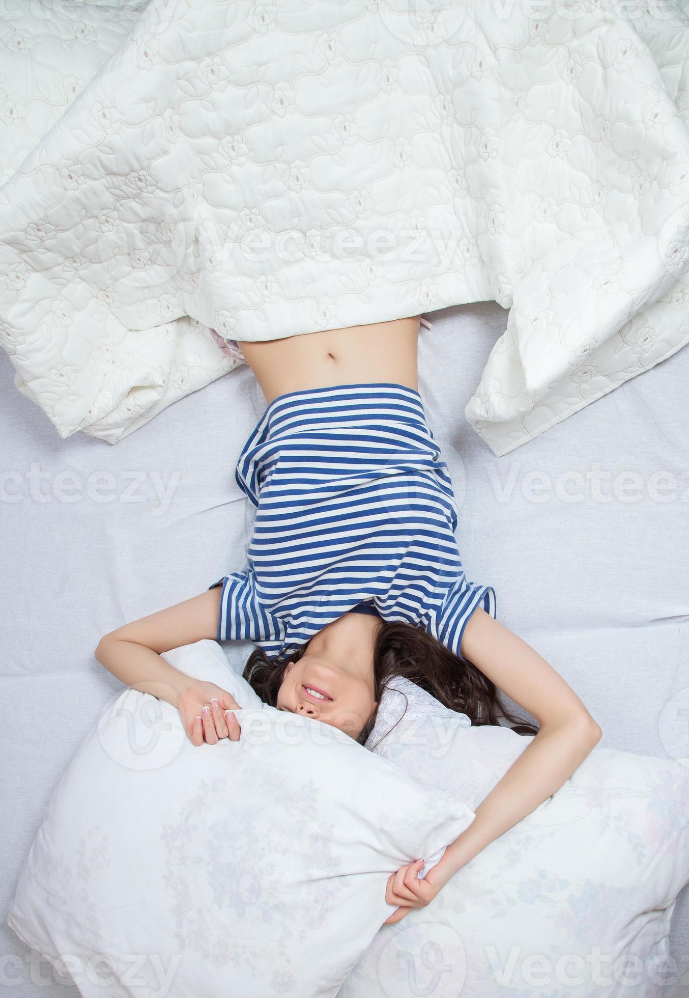 Girl sleeps in a white bed at home. Young woman sleeping in sleepwear