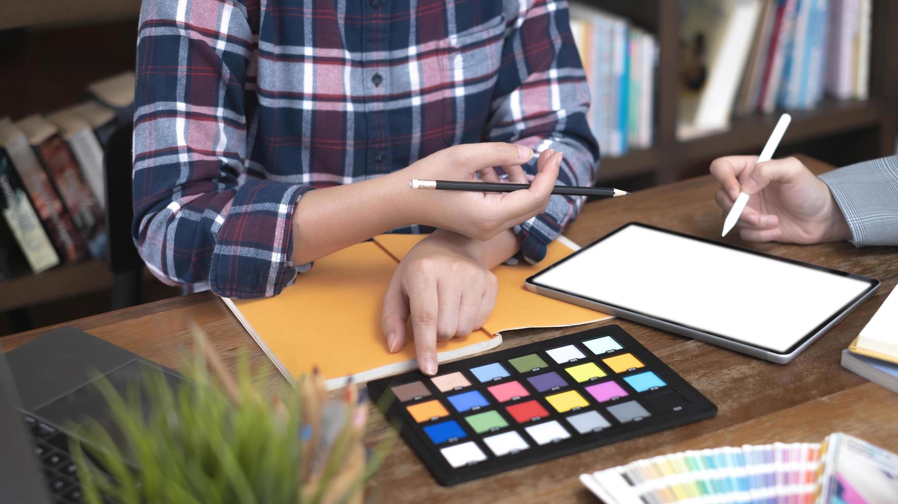 Two artists working on tablet, colour paper tone on workspace at the office photo
