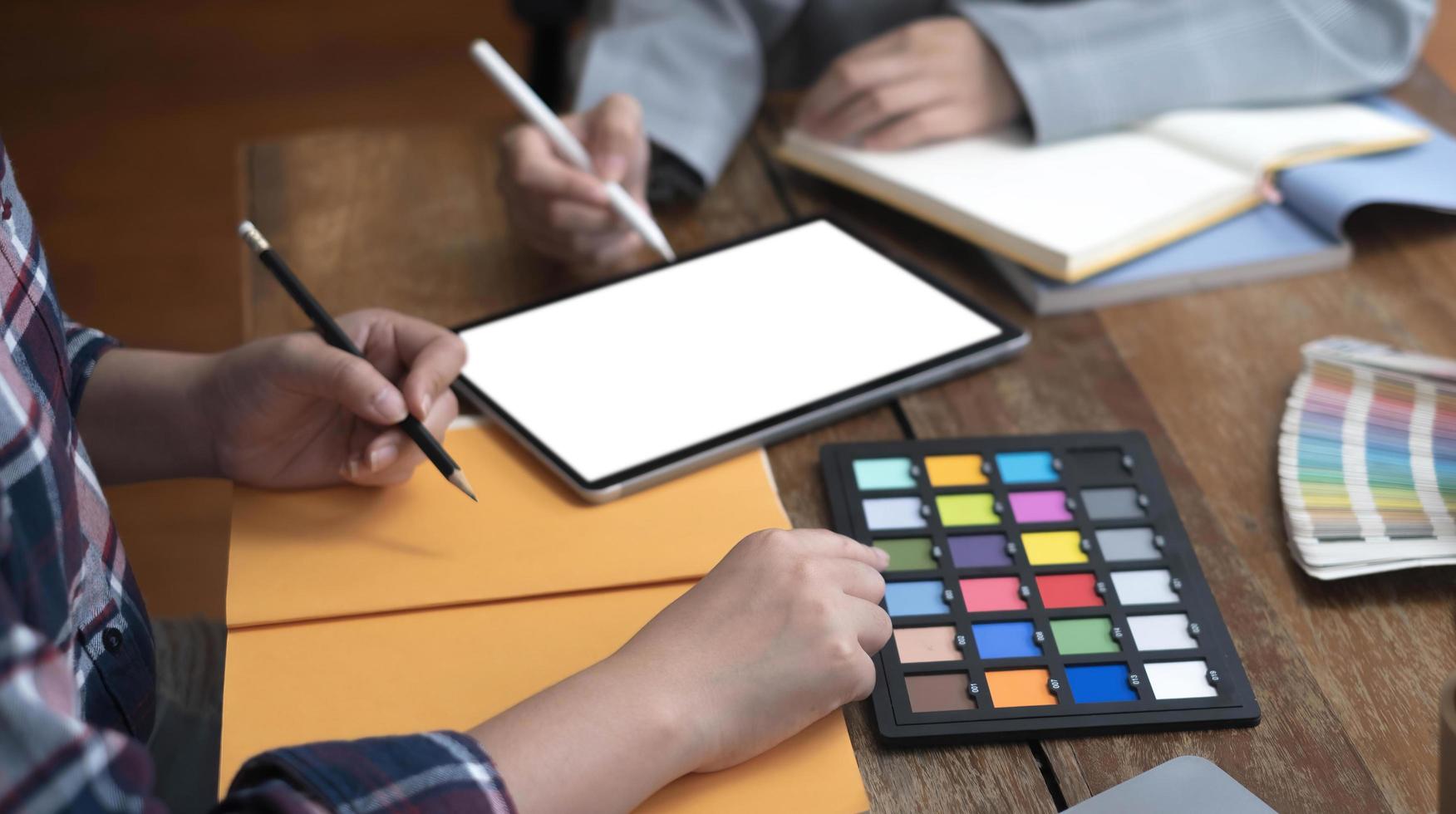 Two artists working on tablet, colour paper tone on workspace at the office photo