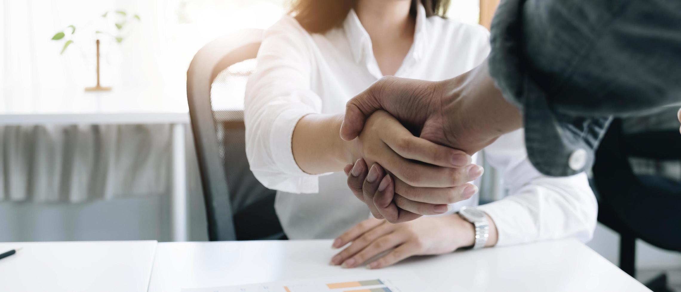 una imagen de primer plano de una empresa dándose la mano en un acuerdo de cooperación empresarial en la oficina. concepto de negocio de cooperación y éxito foto