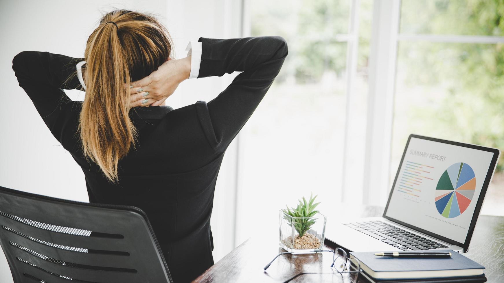 Young asian woman is sitting at work and has pain in her neck photo