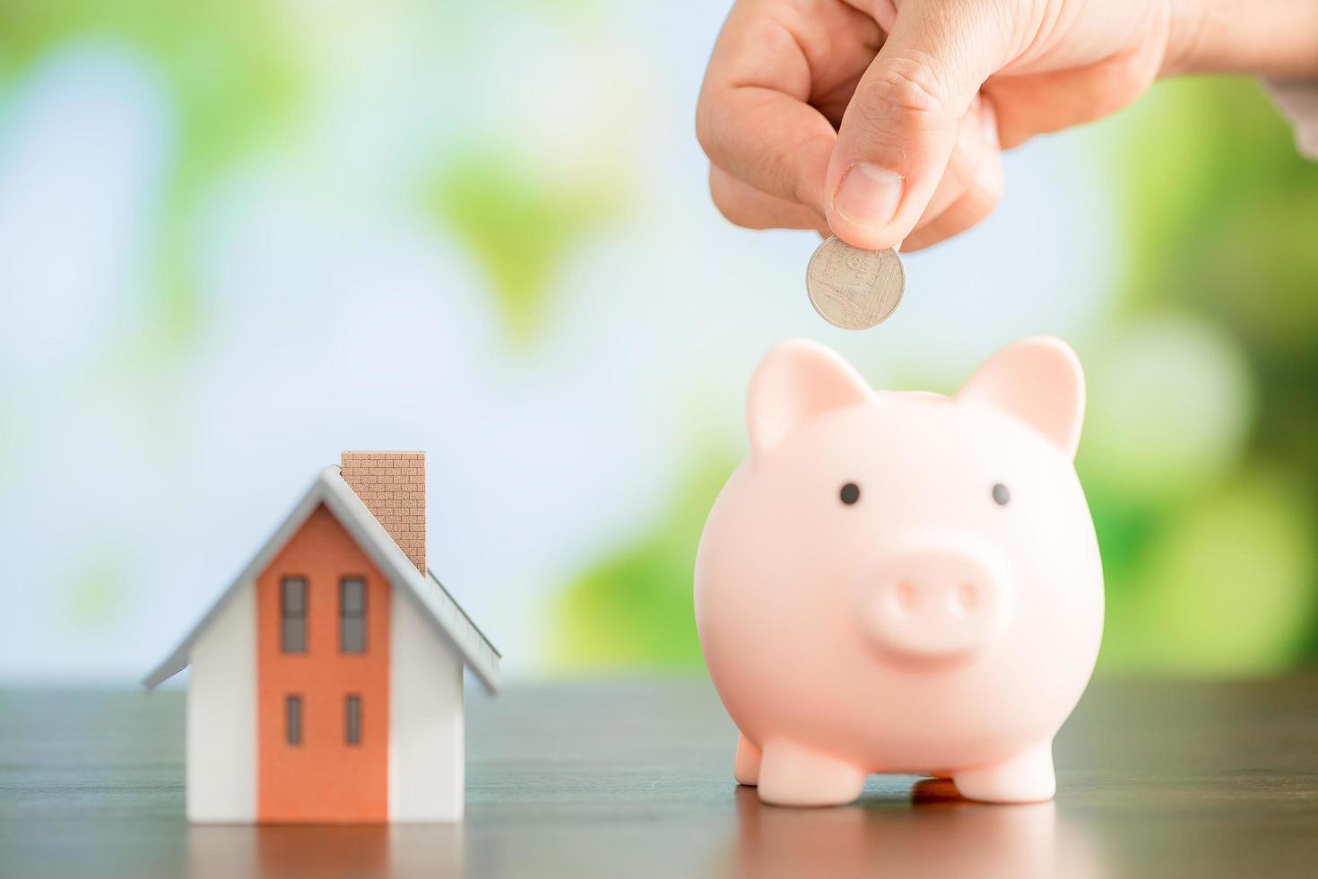 Hand putting coin in a piggy bank photo