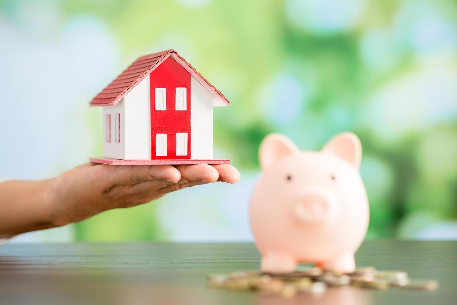 Model house with piggy bank and coins money photo