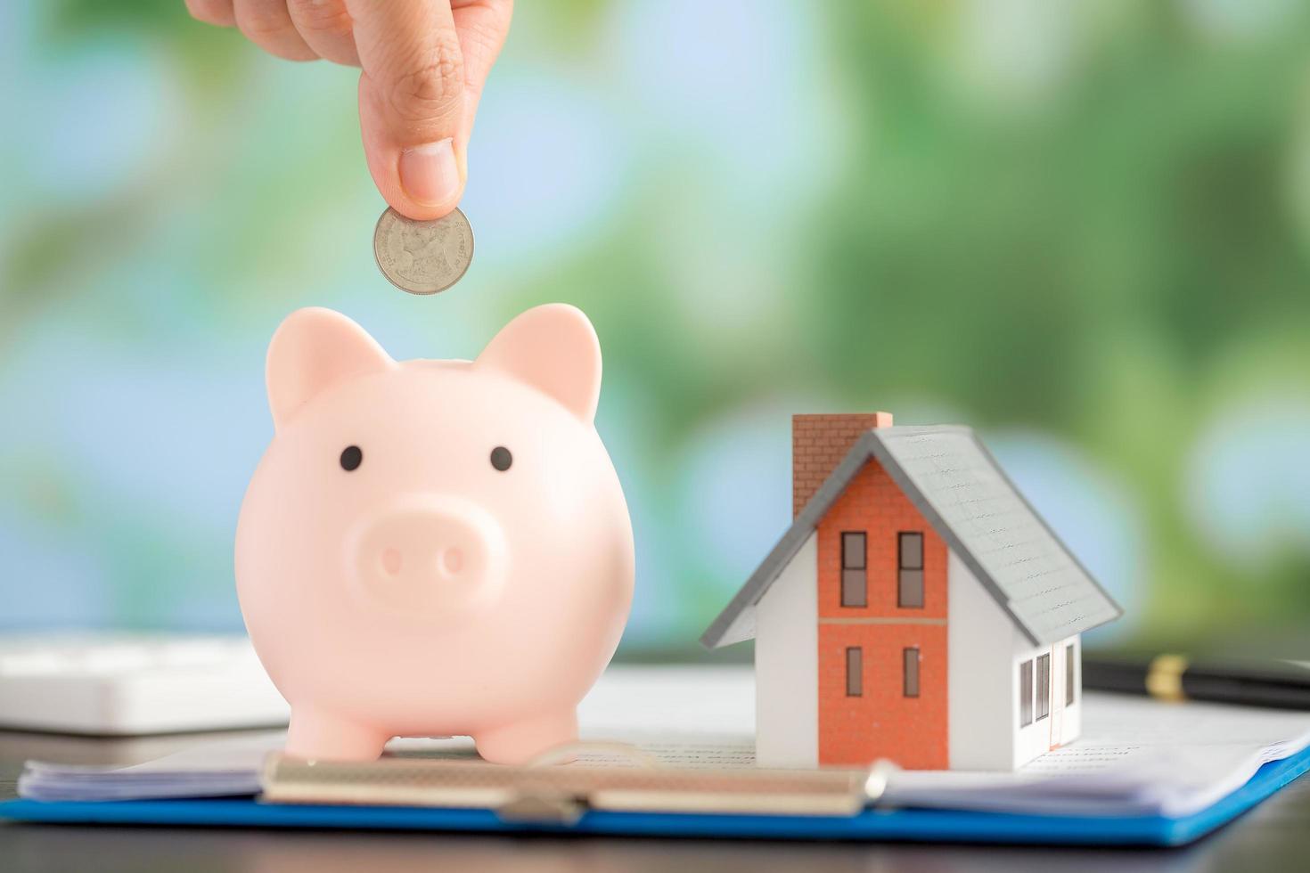 Hand putting coin in a piggy bank photo