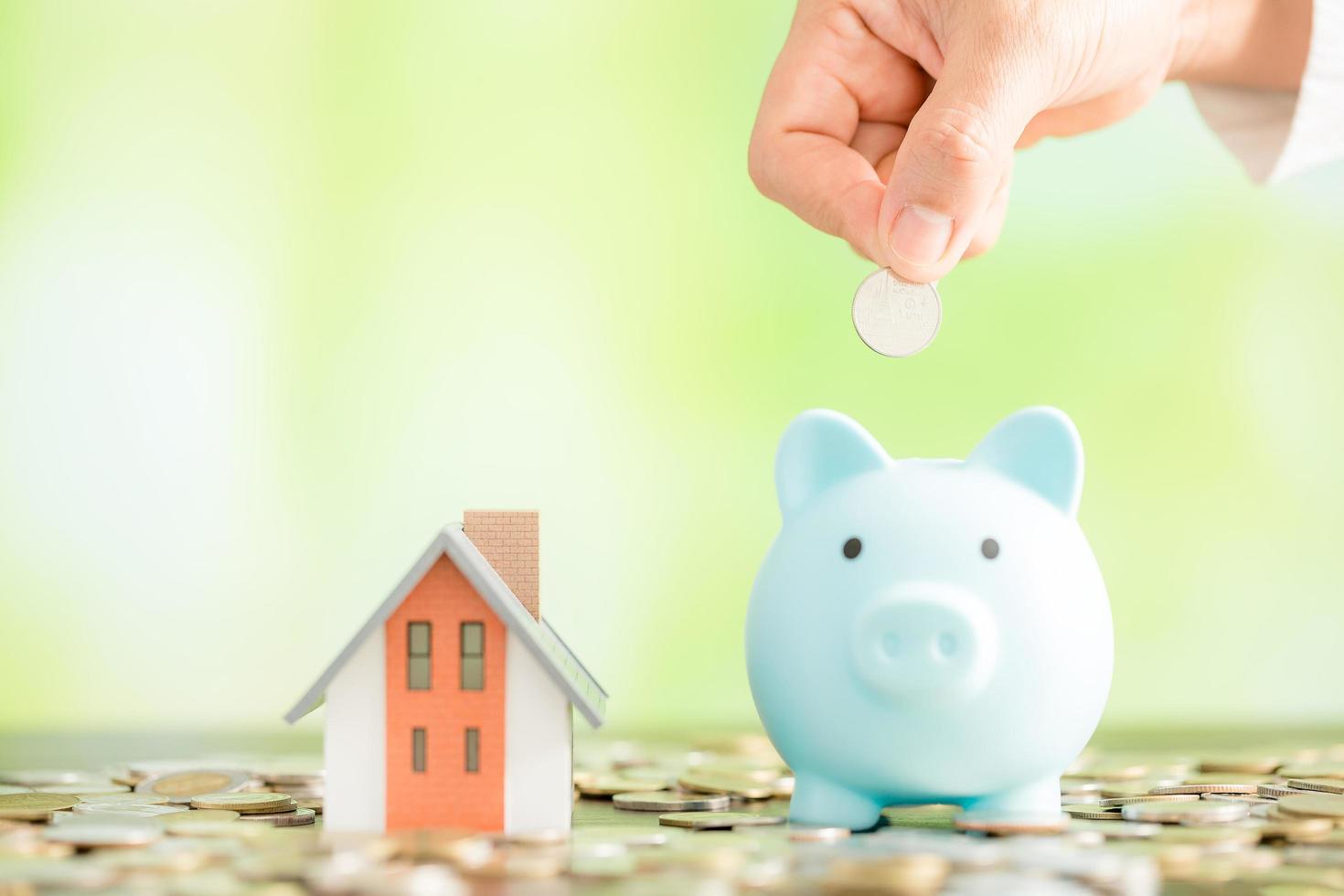 Hand putting coin in a piggy bank photo