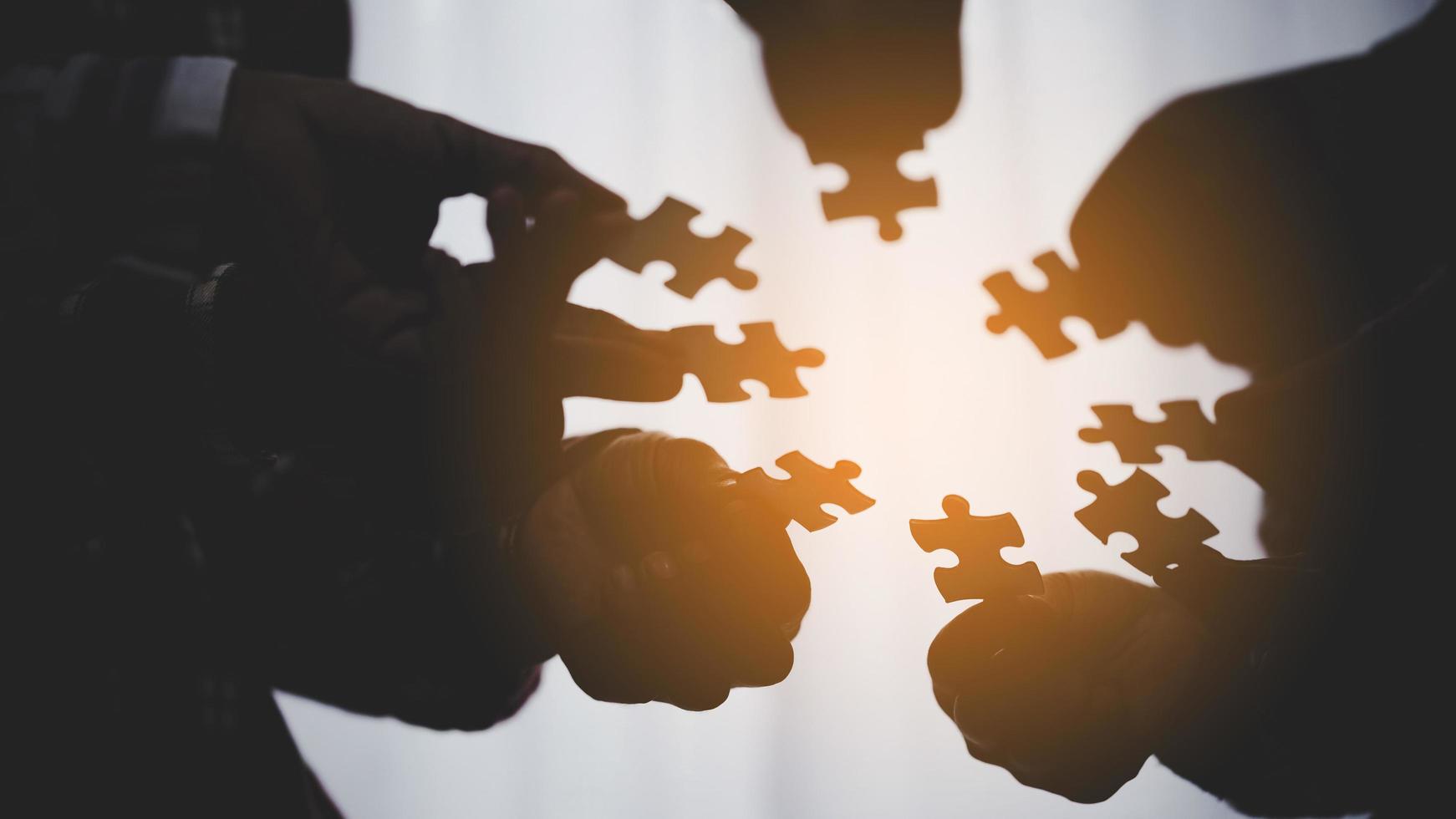 hand of business people connecting jigsaw puzzle photo