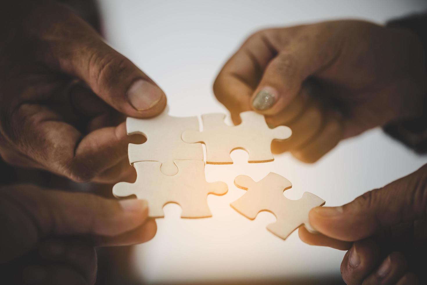 Group of business people assembling jigsaw photo