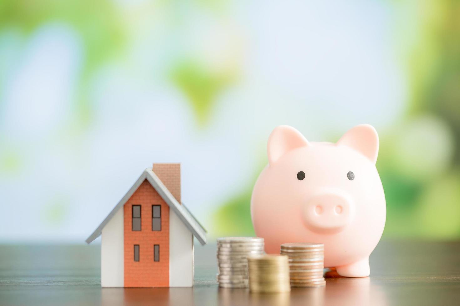 Model house with piggy bank and coins money photo