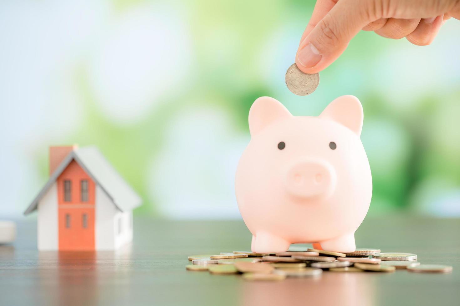 Hand putting coin in a piggy bank photo