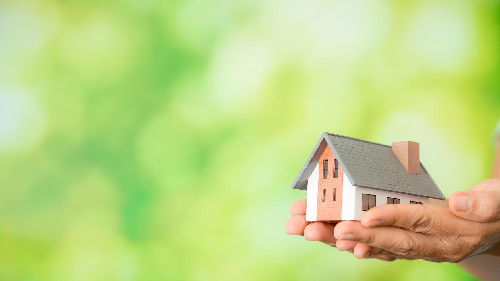 small model house with green bokeh background photo