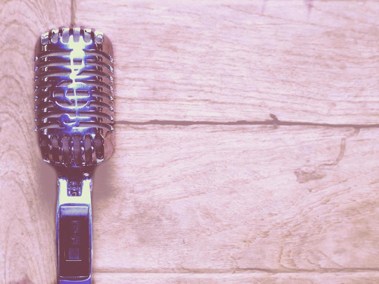 Vintage style classic microphone placed on an old wood. photo