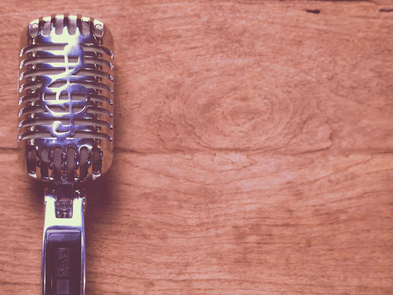 Vintage style classic microphone placed on an old wood. photo