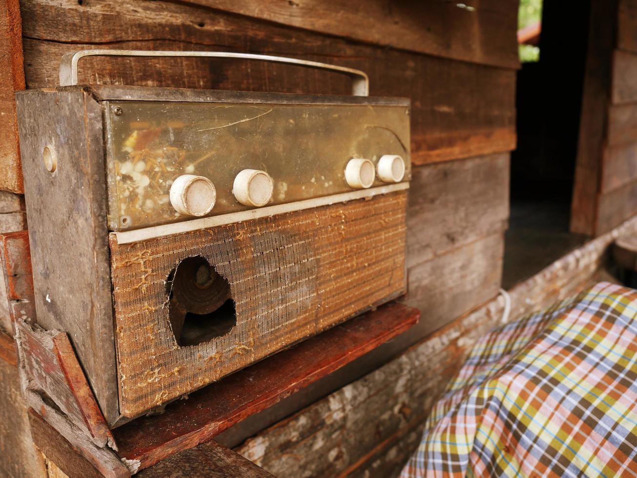 A very old, damaged radio player with an old picture background. photo