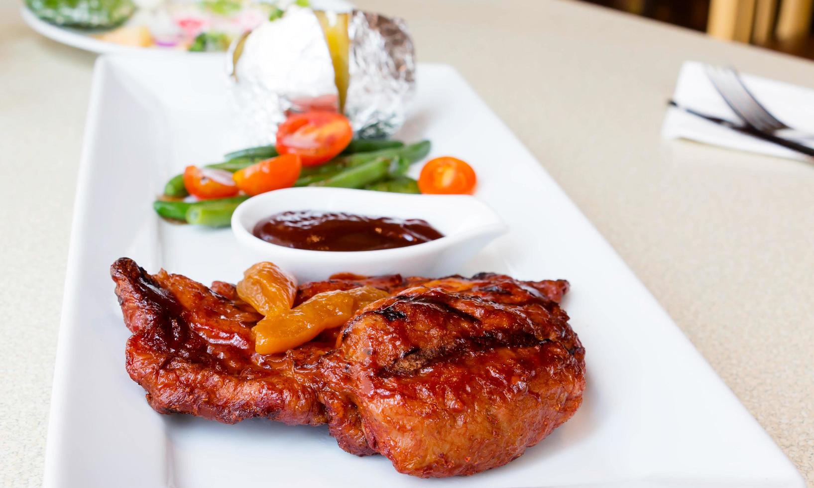 barbeque chichen on white plate in restaurant photo