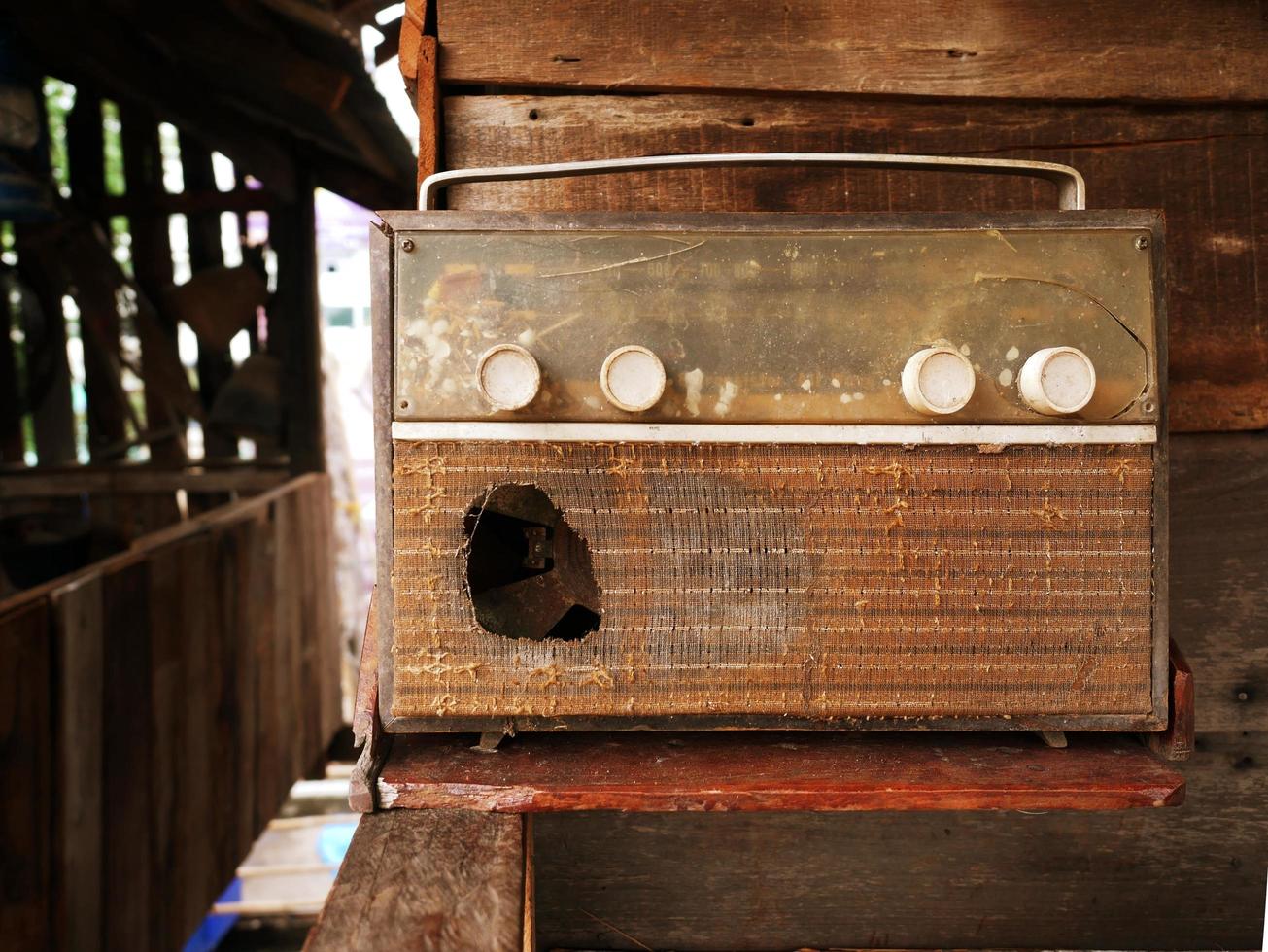 A very old, damaged radio player with an old picture background. photo