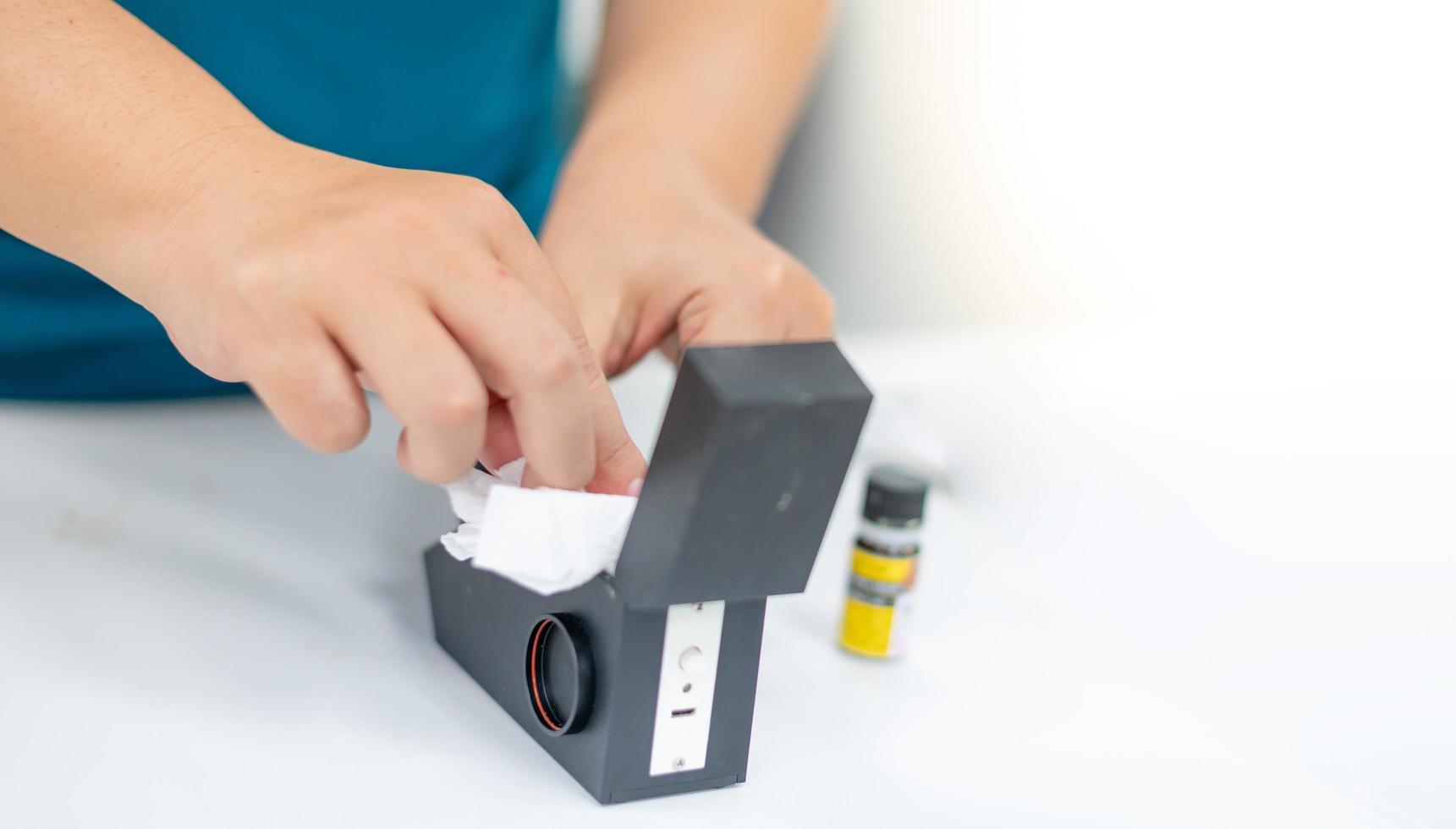 Female use tissue cleaning the refractometer after use and preparing to use the next examing of the precious stone. photo