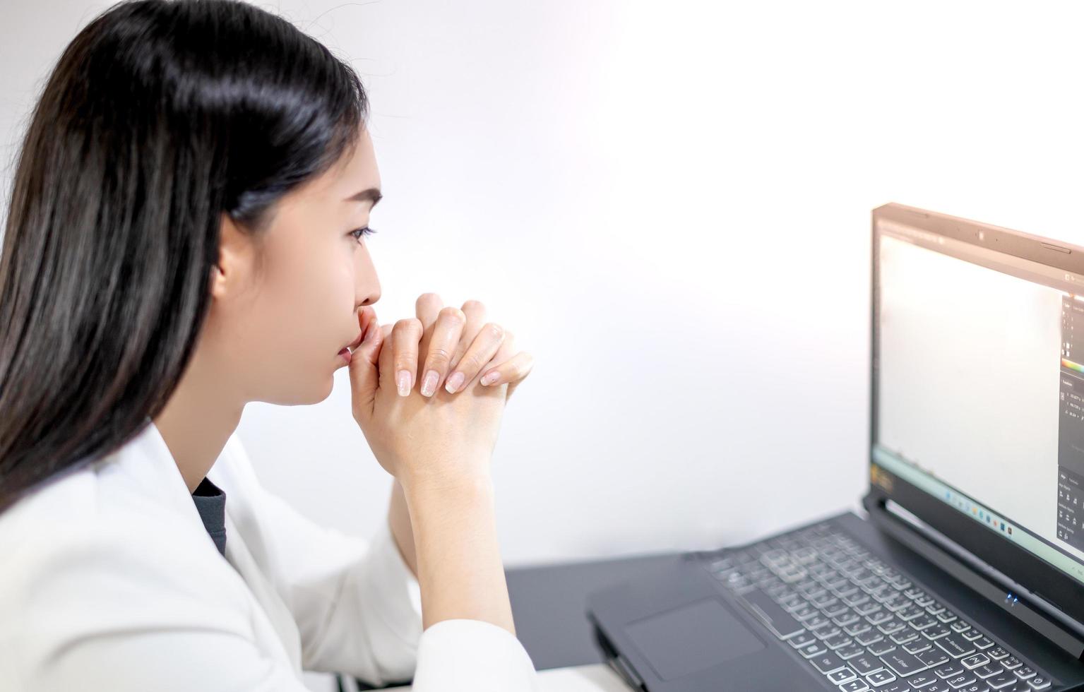 Asian young feeling stress from work, while sitting in front of the laptop in their home. photo