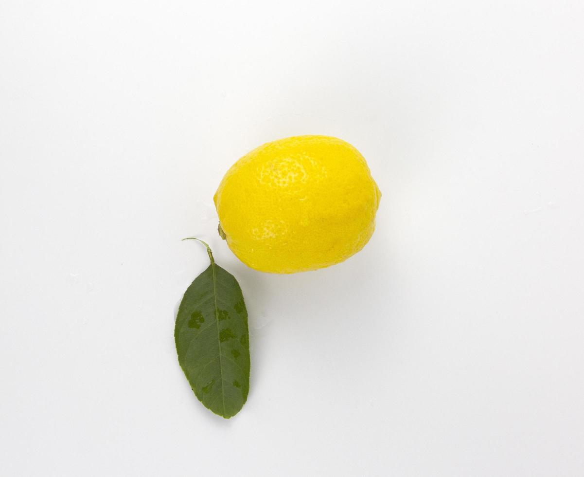 A Fresh yellow Lemon fruit with leaf isolated on white background used in healthy food diet concept photo