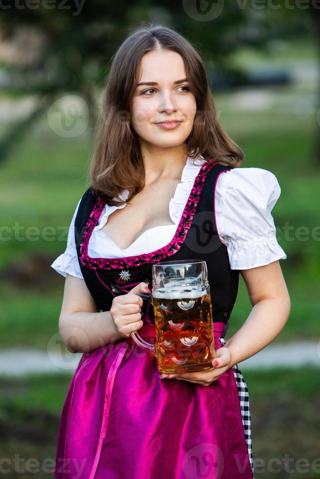 Sexy russian woman in Bavarian dress holding beer mugs. photo