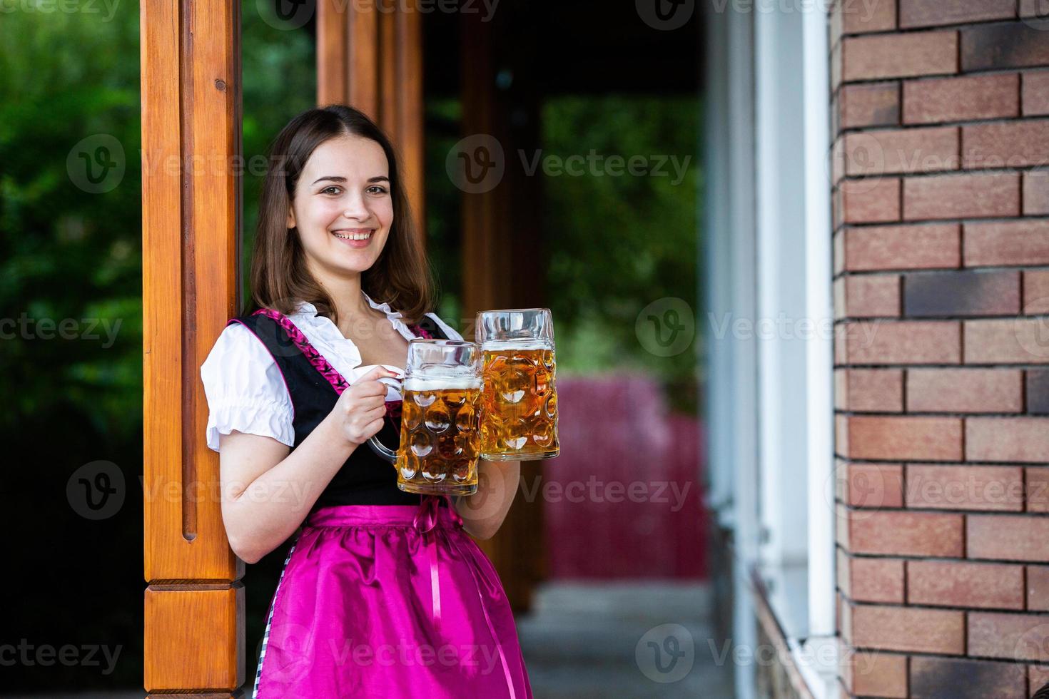 Sexy russian woman in Bavarian dress holding beer mugs. photo