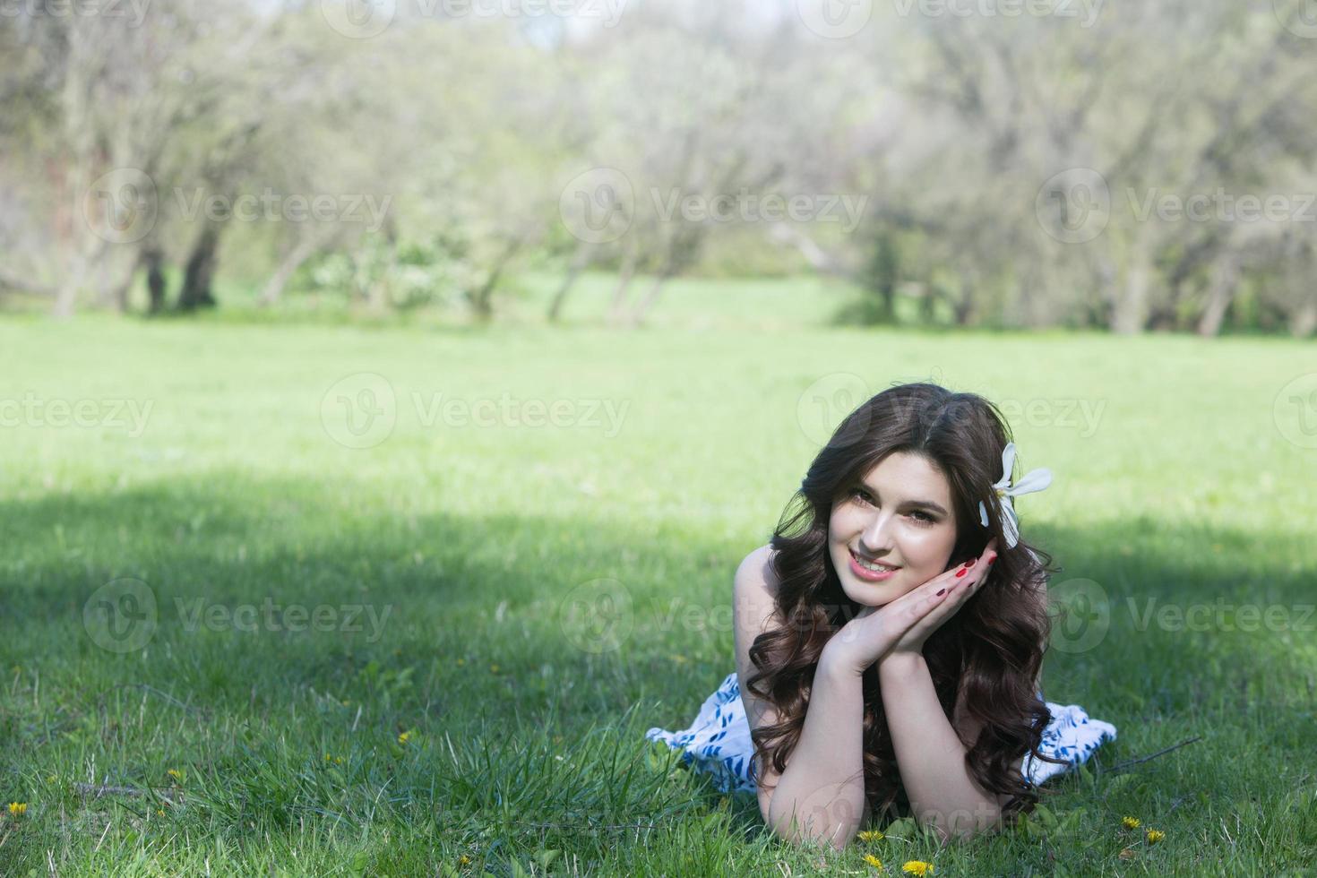 beautiful white european girl with clean skin in the park with flowering trees photo