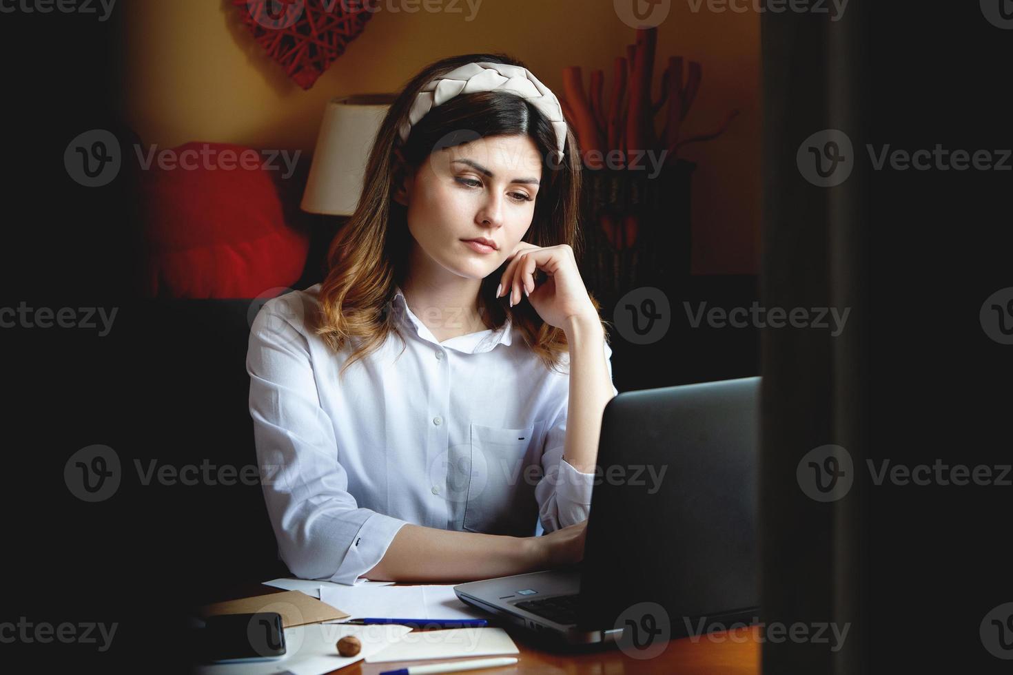 The girl works at the computer in a cafe. Student learning online. Blogger. Young Caucasian female writer keyboarding on laptop. attractive businesswoman using portable computer during a break. photo