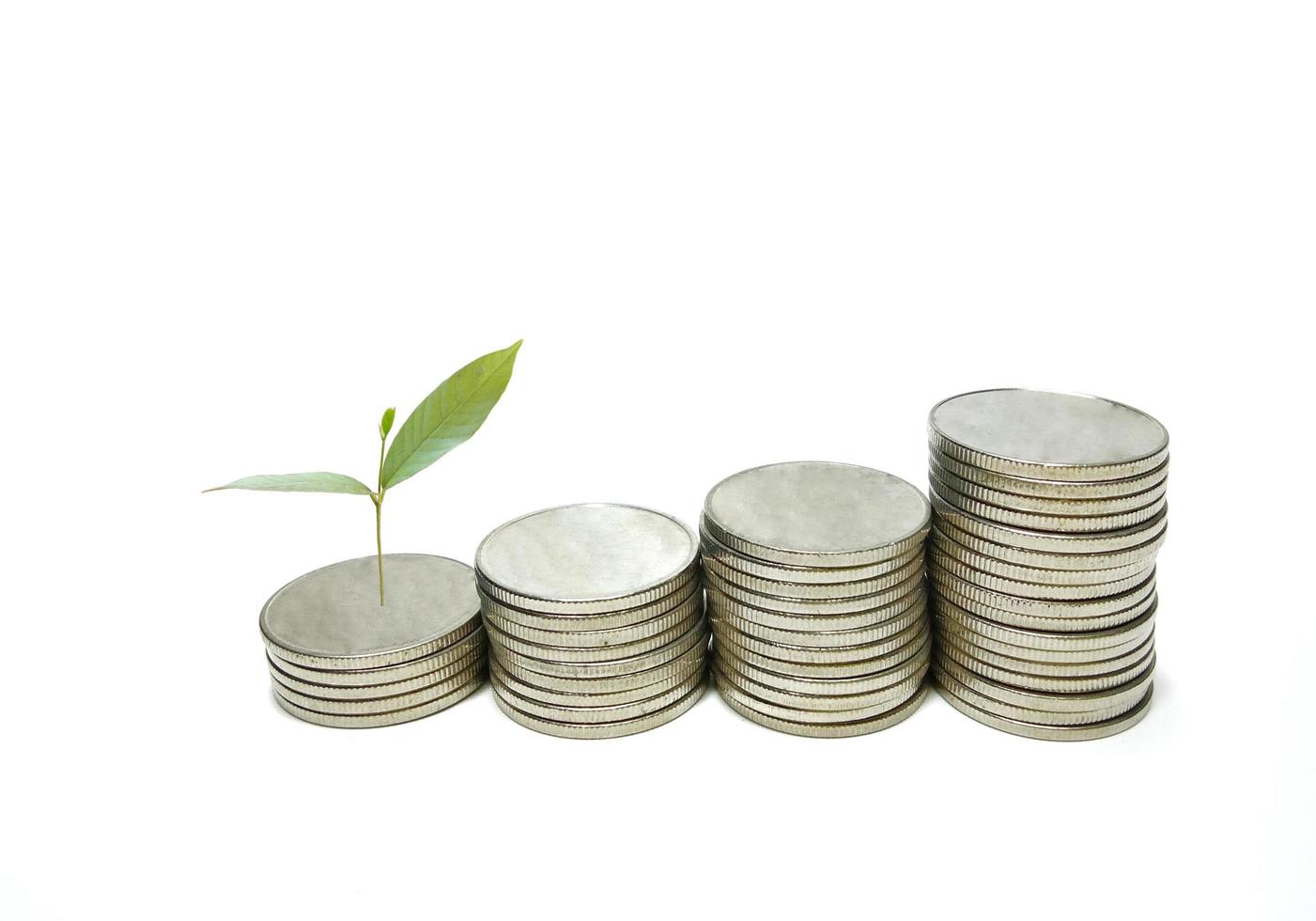 Silver metal coins stacked with small green trees. White background gives the concept of growth. Financial business, saving money, interest, giving a feeling of wealth and stability in life. photo