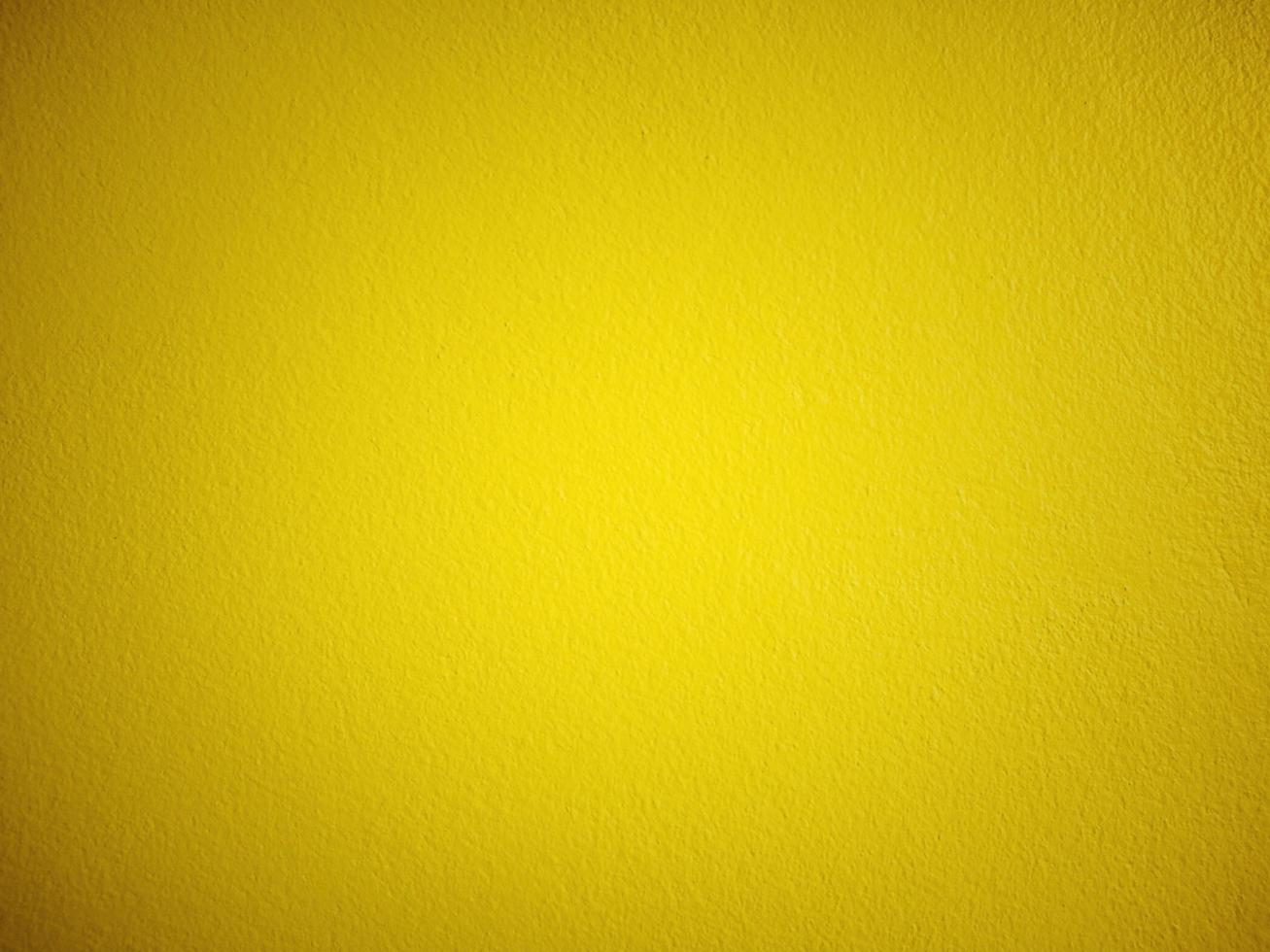 Background of plaster wall painted in yellow, vignette, vintage style. photo