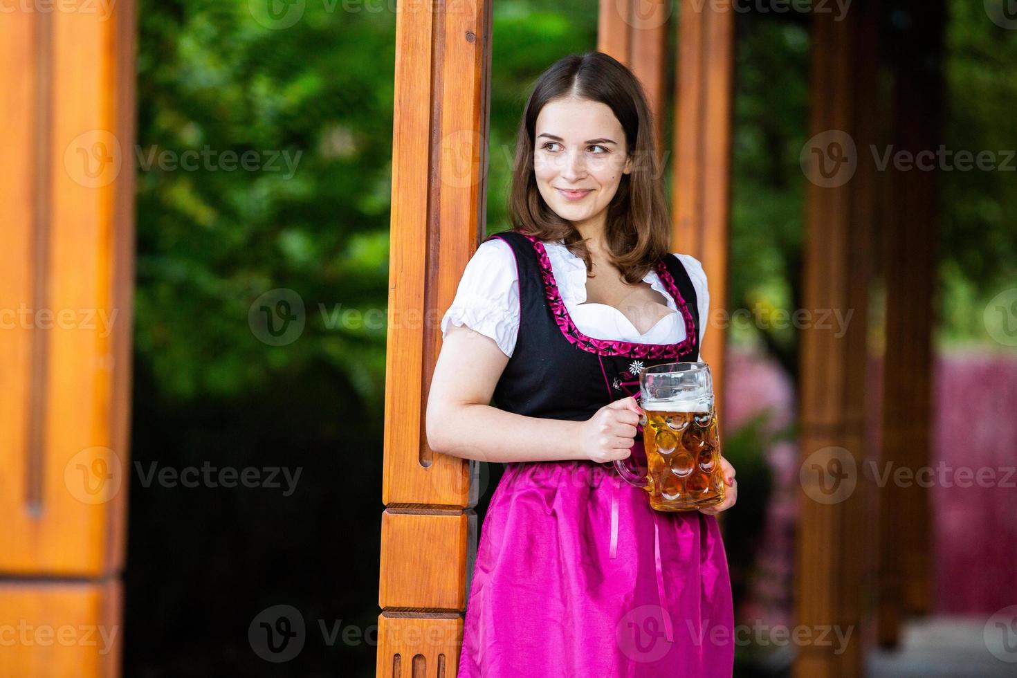 mujer rusa sexy con vestido bávaro sosteniendo jarras de cerveza. foto