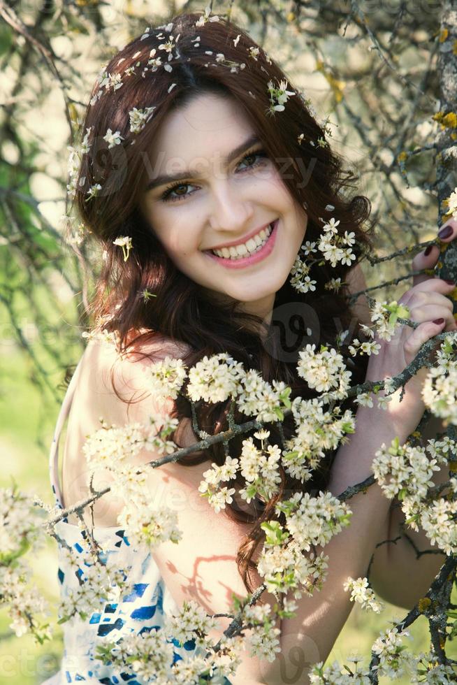 beautiful white european girl with clean skin in the park with flowering trees photo