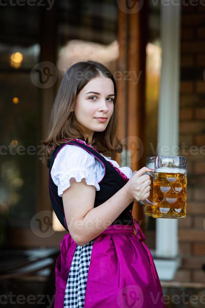 Sexy russian woman in Bavarian dress holding beer mugs. photo