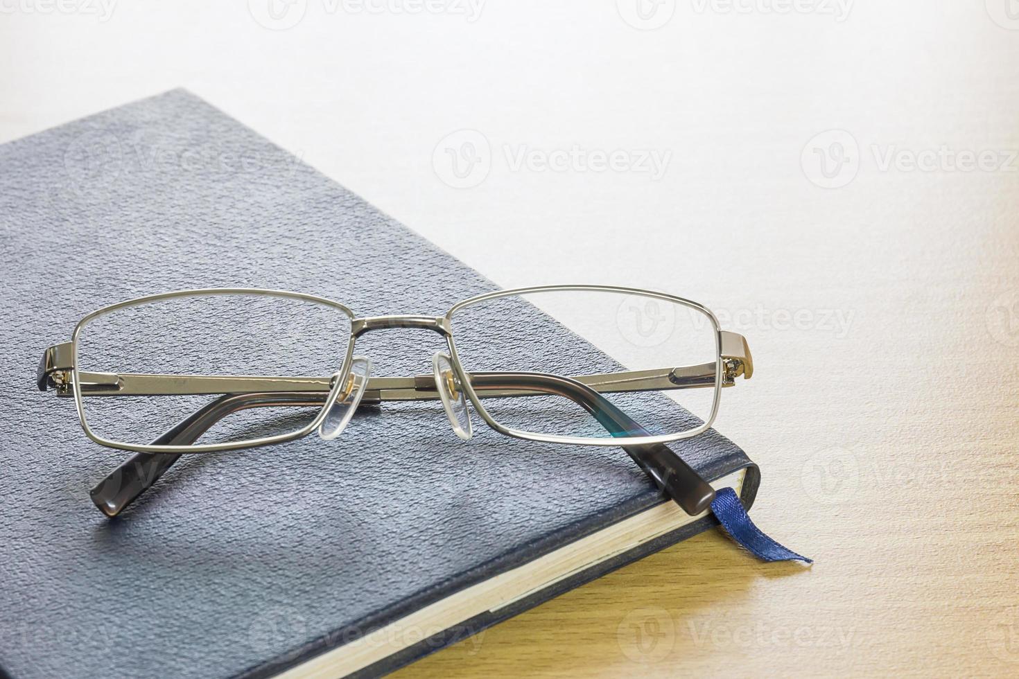 Glasses put on text book photo