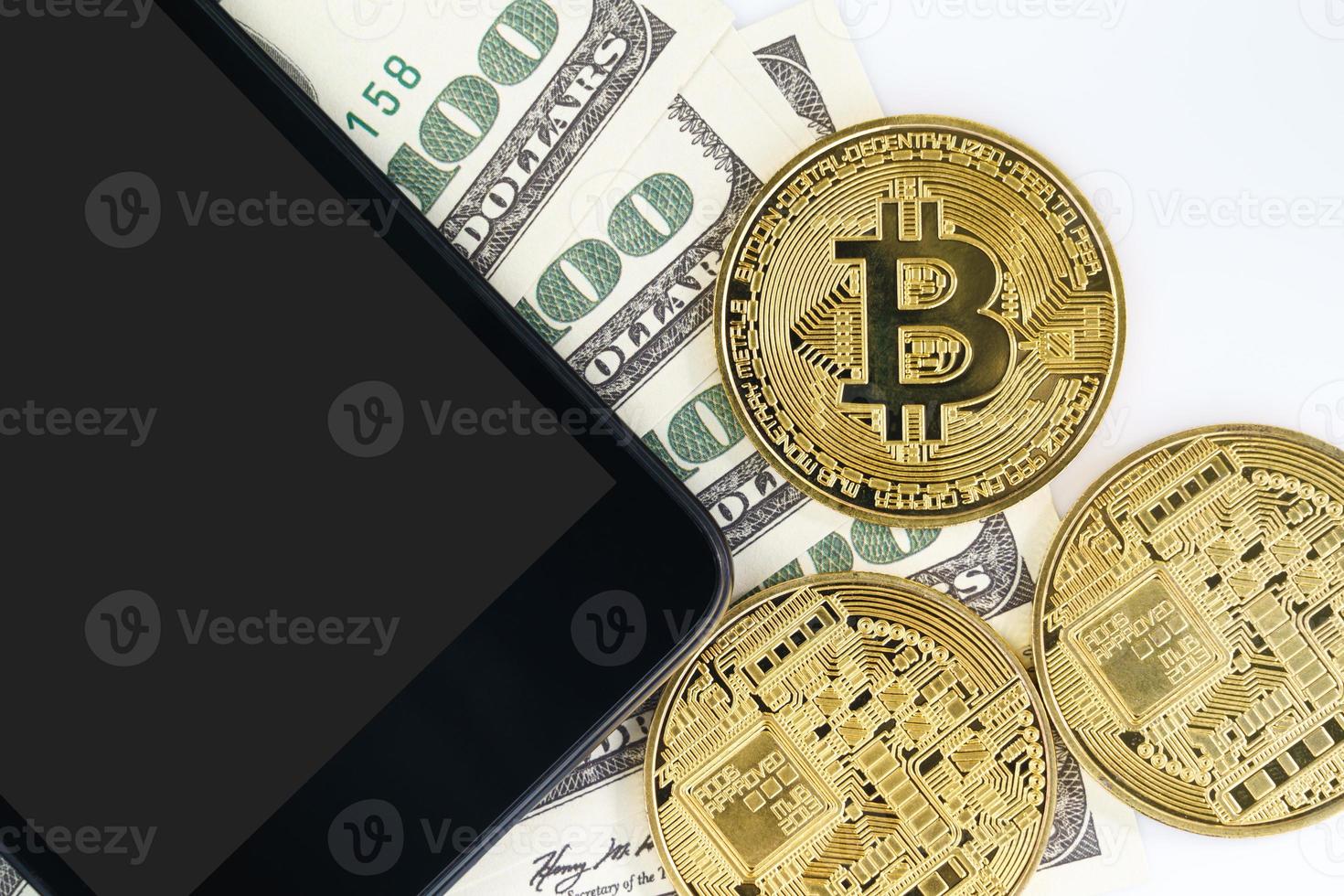 Top view Bitcoins coin and  US banknotes of one hundred dollars with smartphone photo