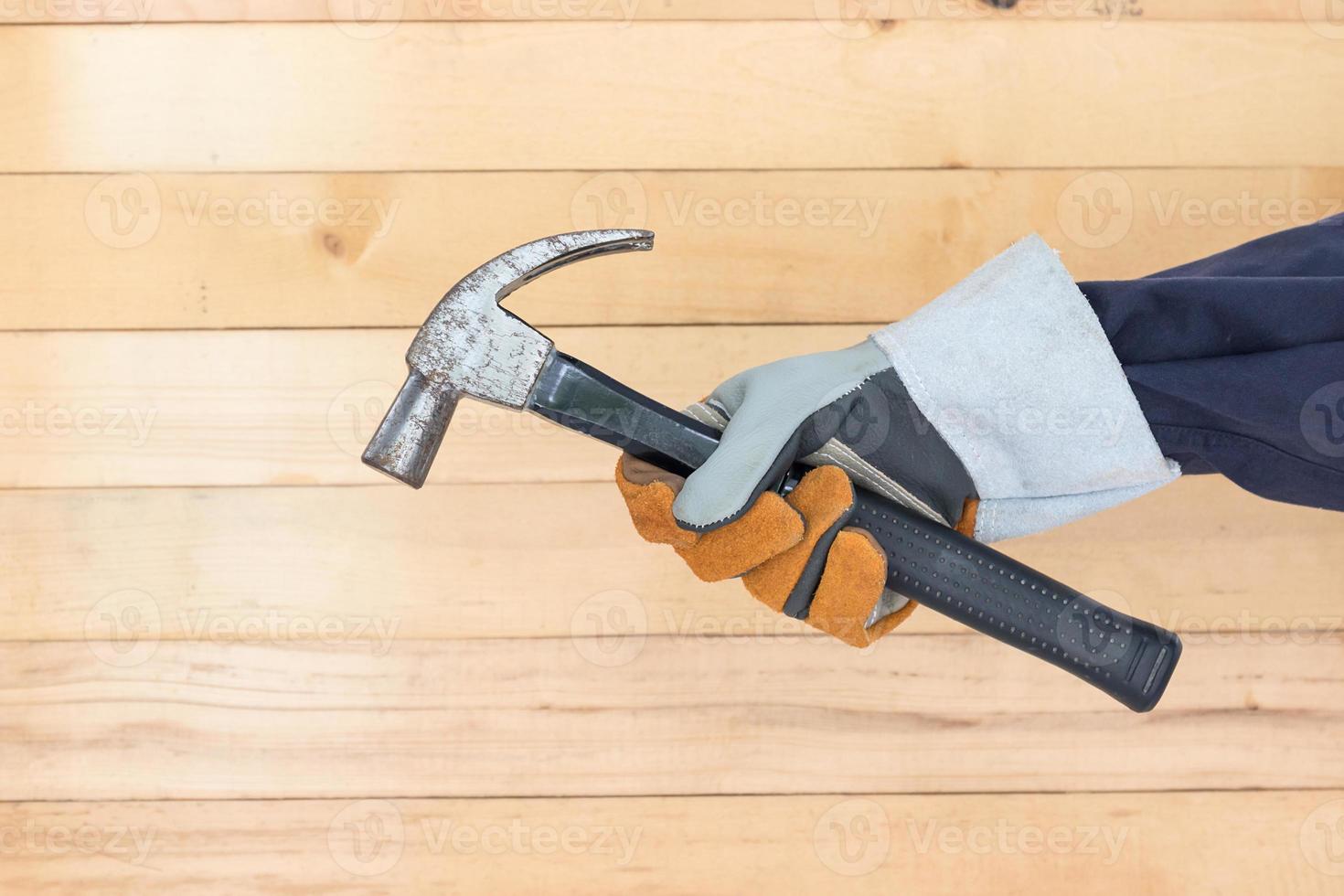 Hand in glove holding hammer photo