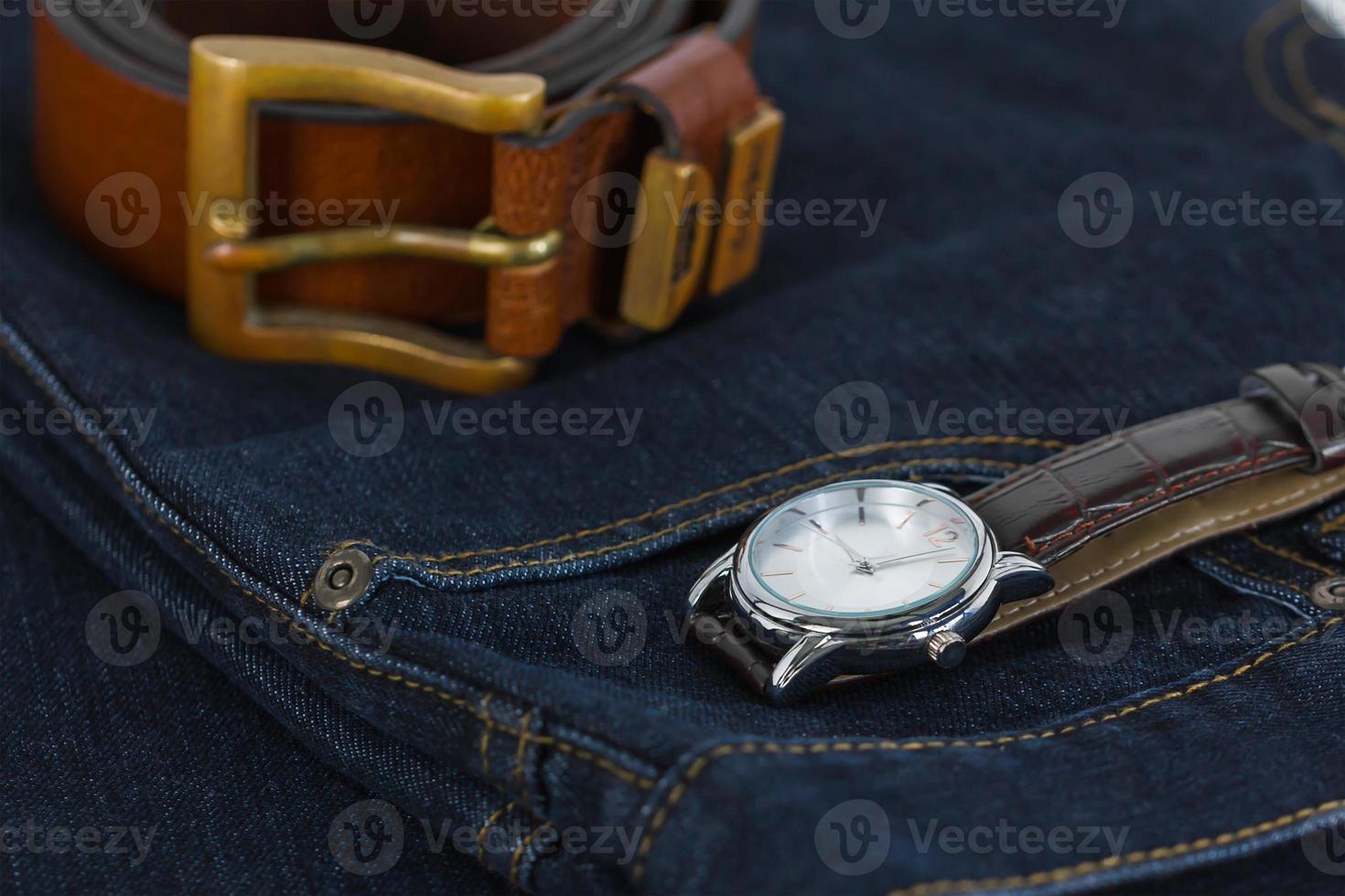 Wrist watch and leather belt on jeans photo