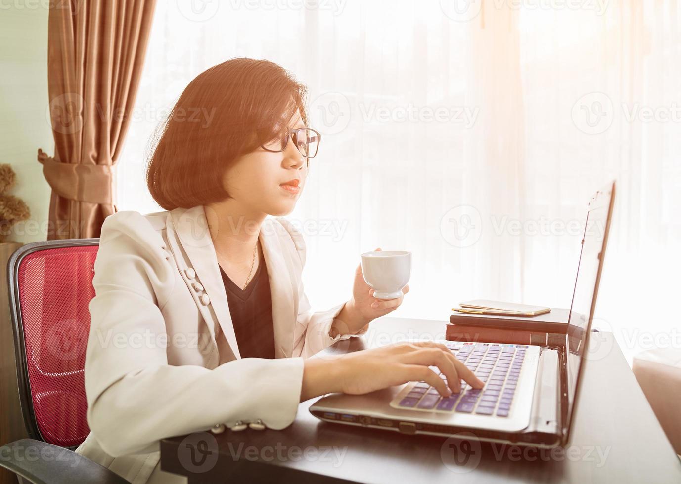 Woman teenage working on laptop in home office photo