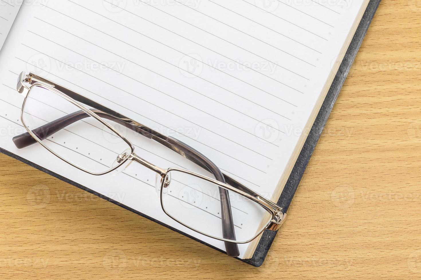 Notebook open blank page and Eyeglasses photo