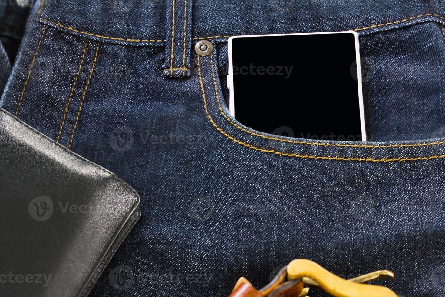 Wallet and smartphone on denim jeans photo