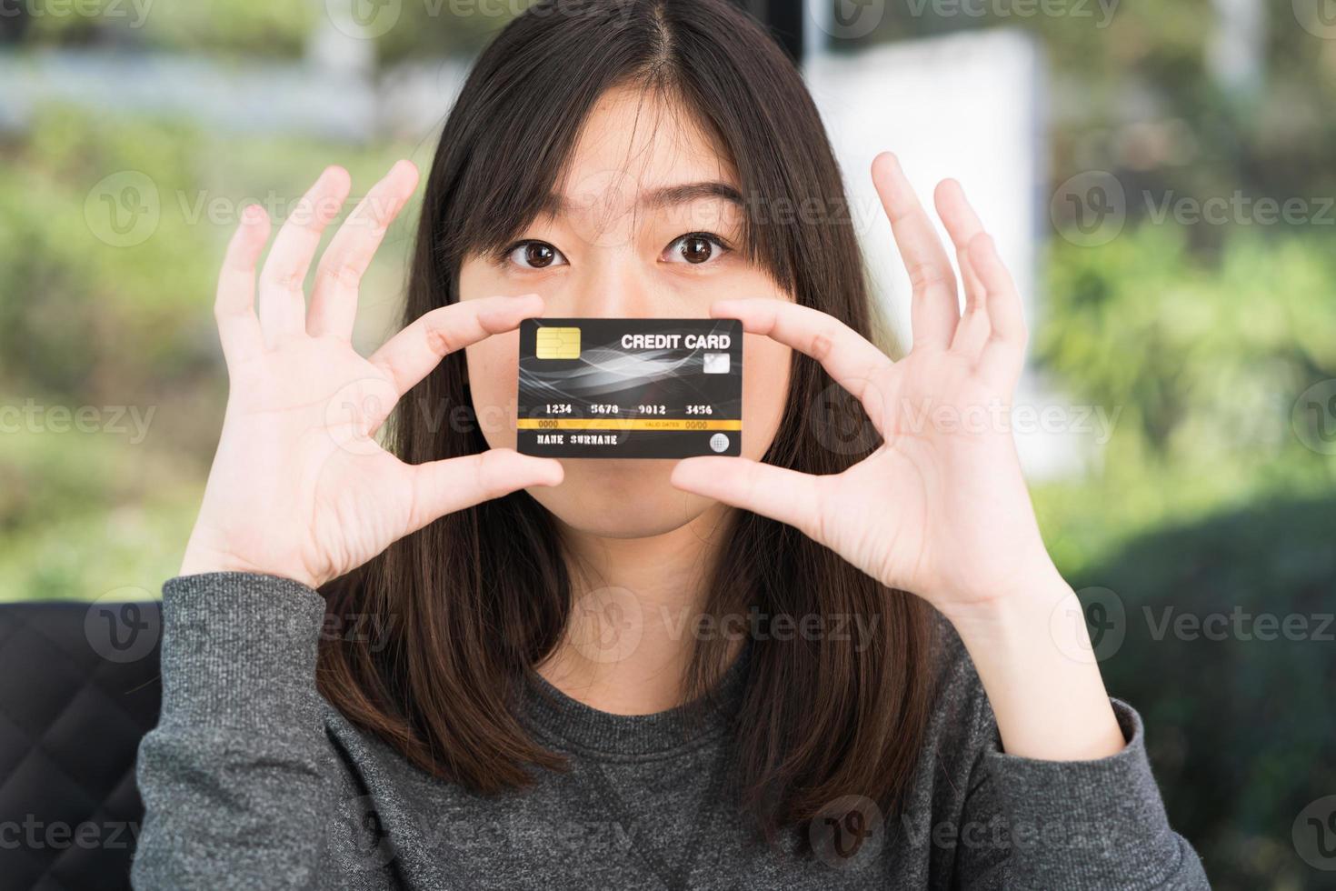 Close up young woman holding credit card photo