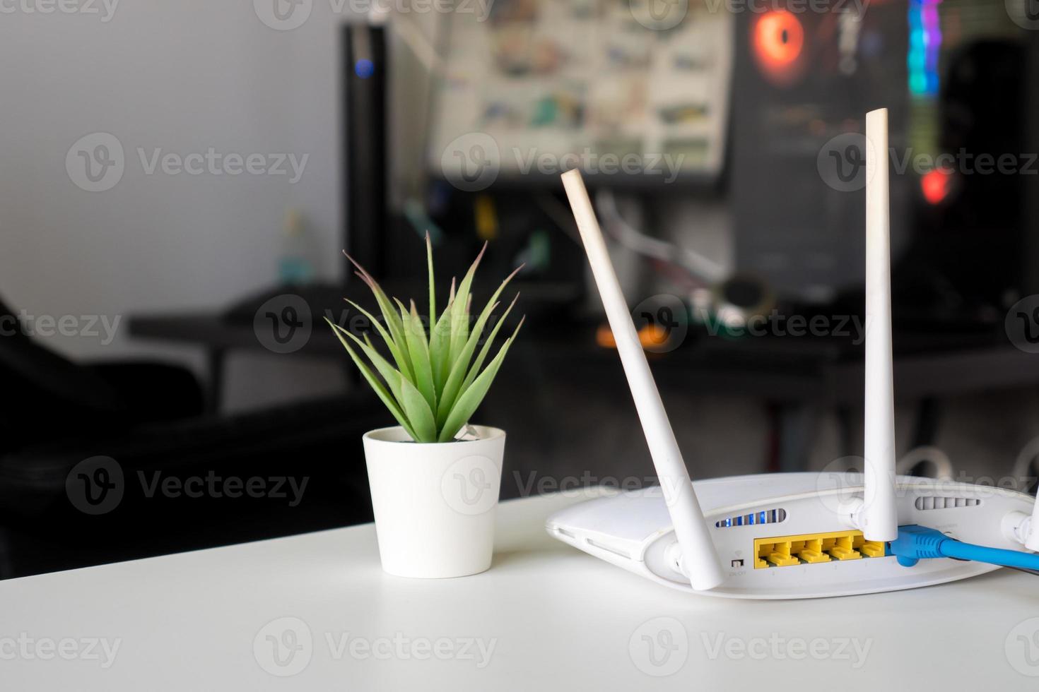 Close up of a wireless router on table at home with desktop computer background photo