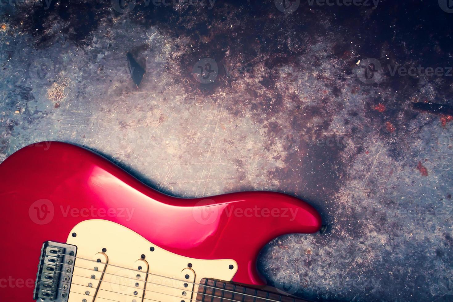 A red electric guitar on a grunge background. photo